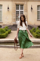 A lady wears a green skirt and a shirt.